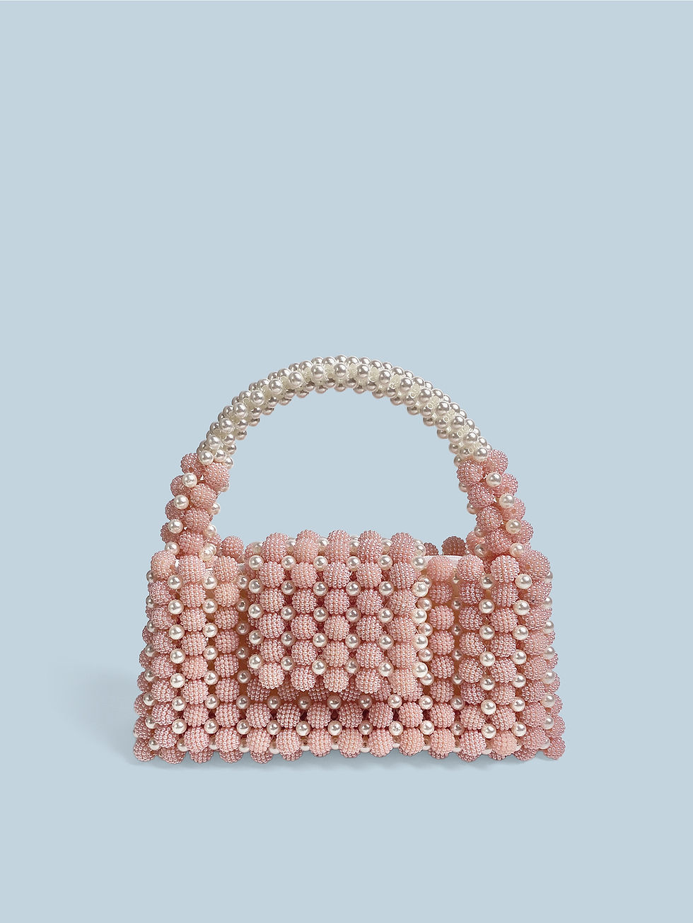 Pink beaded handbag with pearl handle, Pearl Loft, against a light blue backdrop