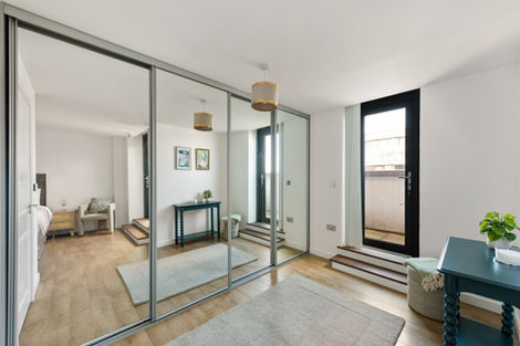 Room with mirrored sliding doors and wooden flooring.