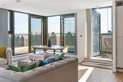 Modern living room with large windows and balcony.