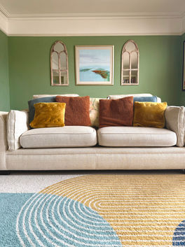 Colourful London living room with mirrored wall hangings and blue, white and yellow modern rug