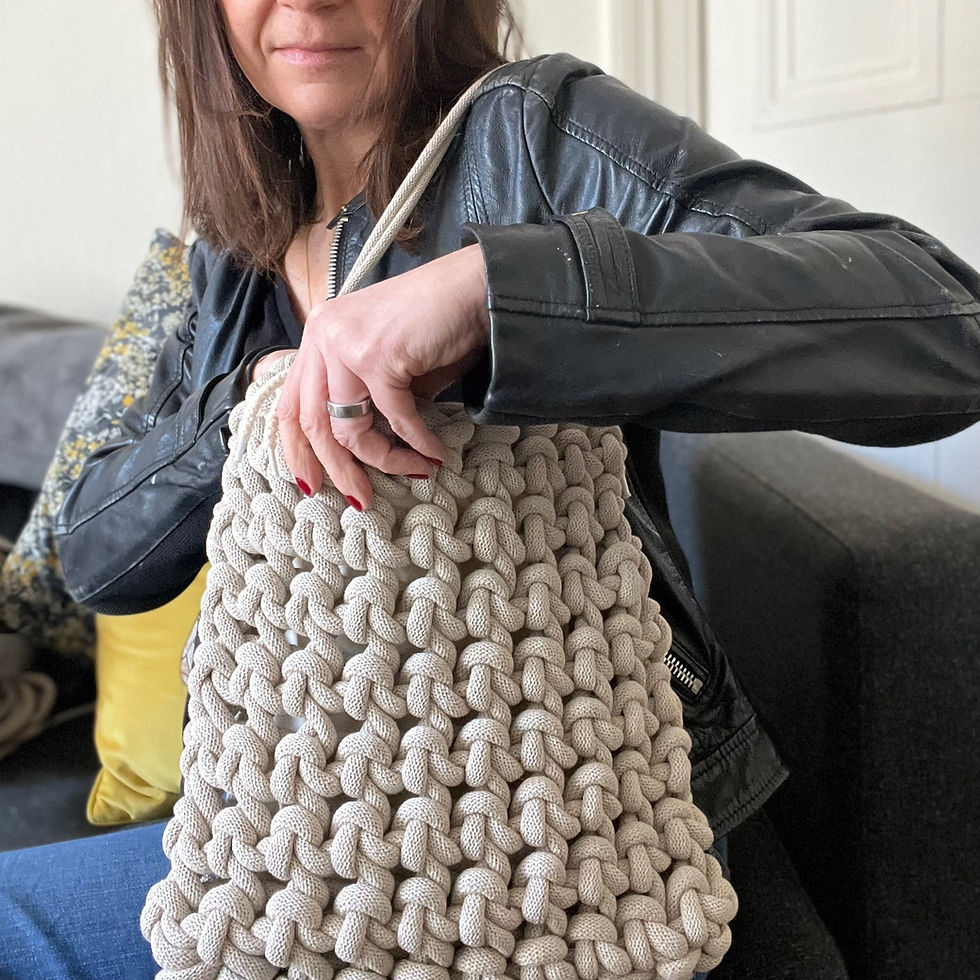 Thumbnail: lady sitting using beige knotted cotton cord shoulder bag with drawstring inner bag