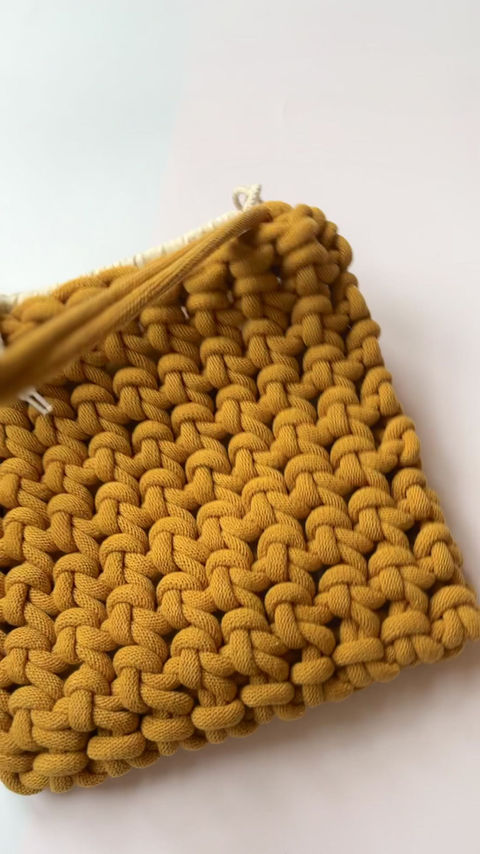Thumbnail: video of yellow chunky knotted shoulder bag with drawstring inner