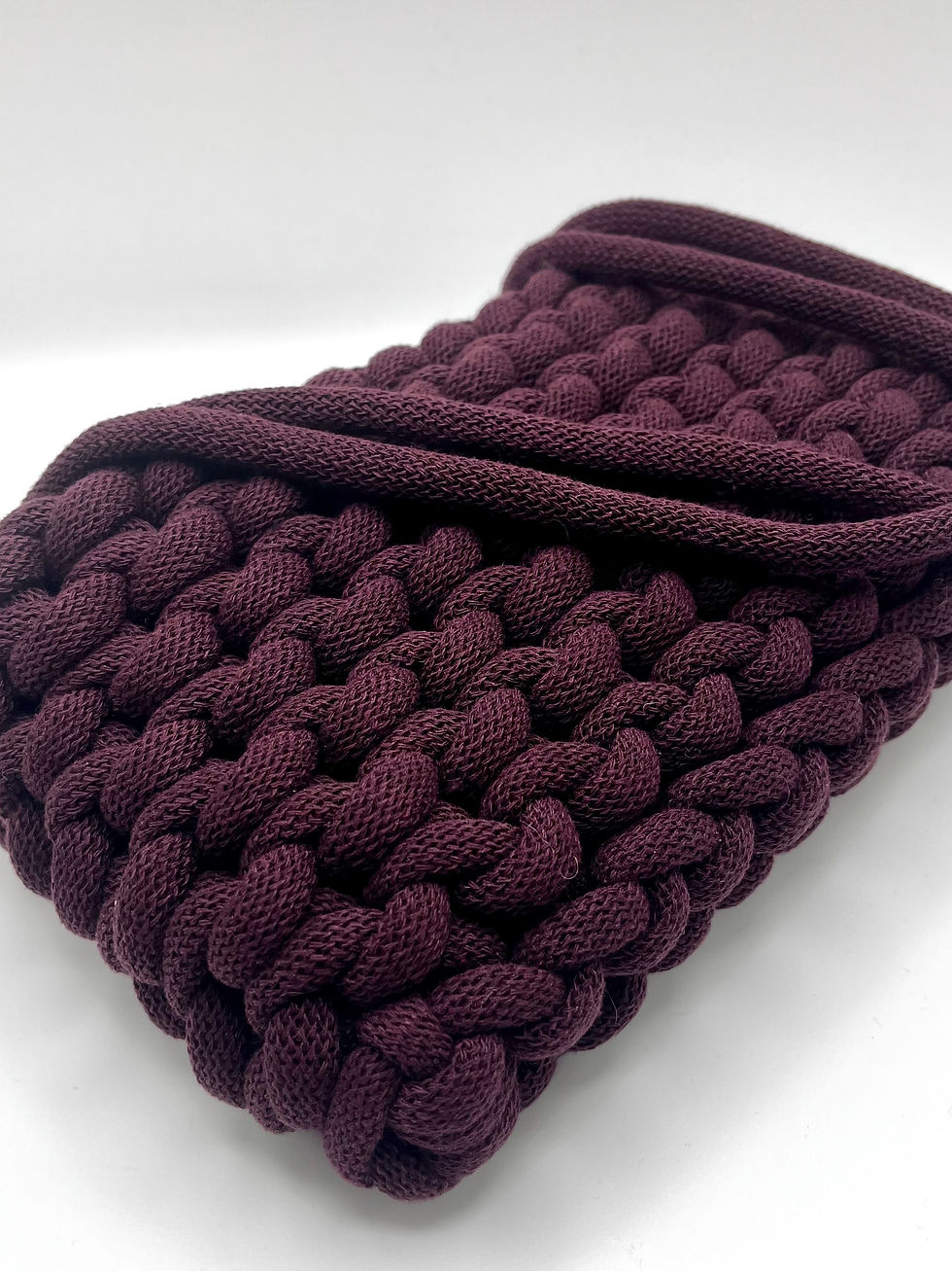 Thumbnail: close up showing braided/knotted design of dark burgundy shoulder bag