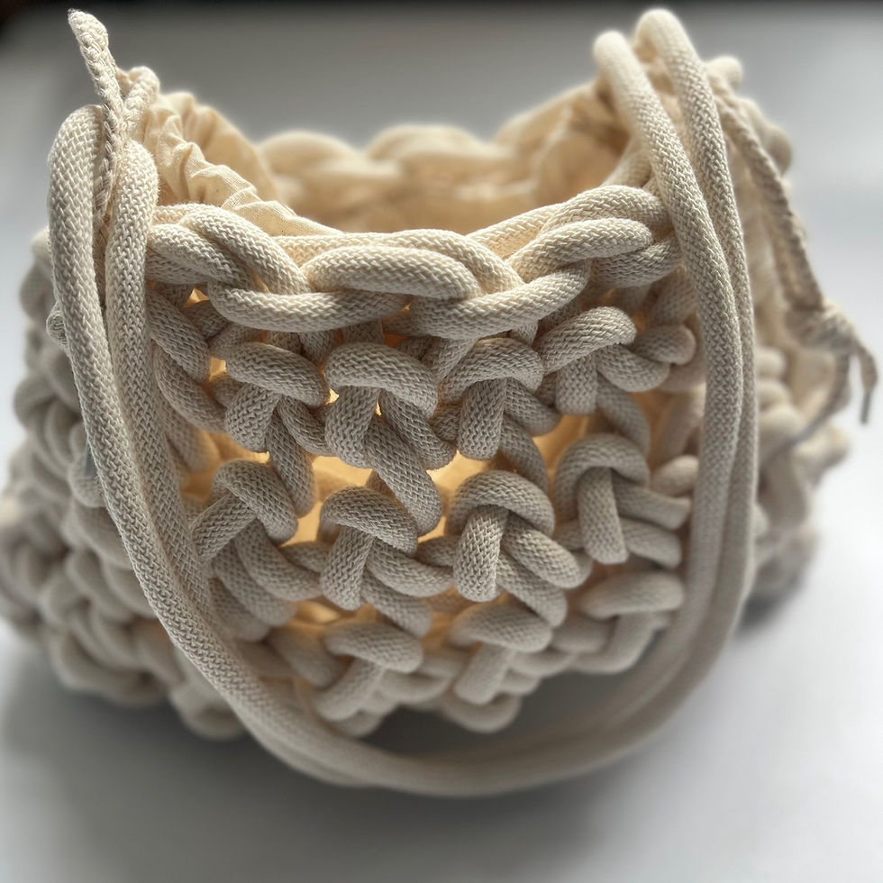 Thumbnail: close up of top view of off white chunky knotted cotton cord bag with a neutral drawstring inner bag