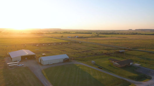 Farm fields and a barn at sunset.