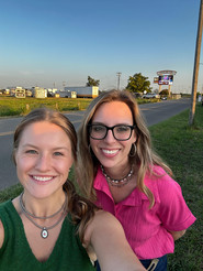 Ruth Inman and Elizabeth Perdue smiling women pose for a selfie on a sunny, outdoor day.