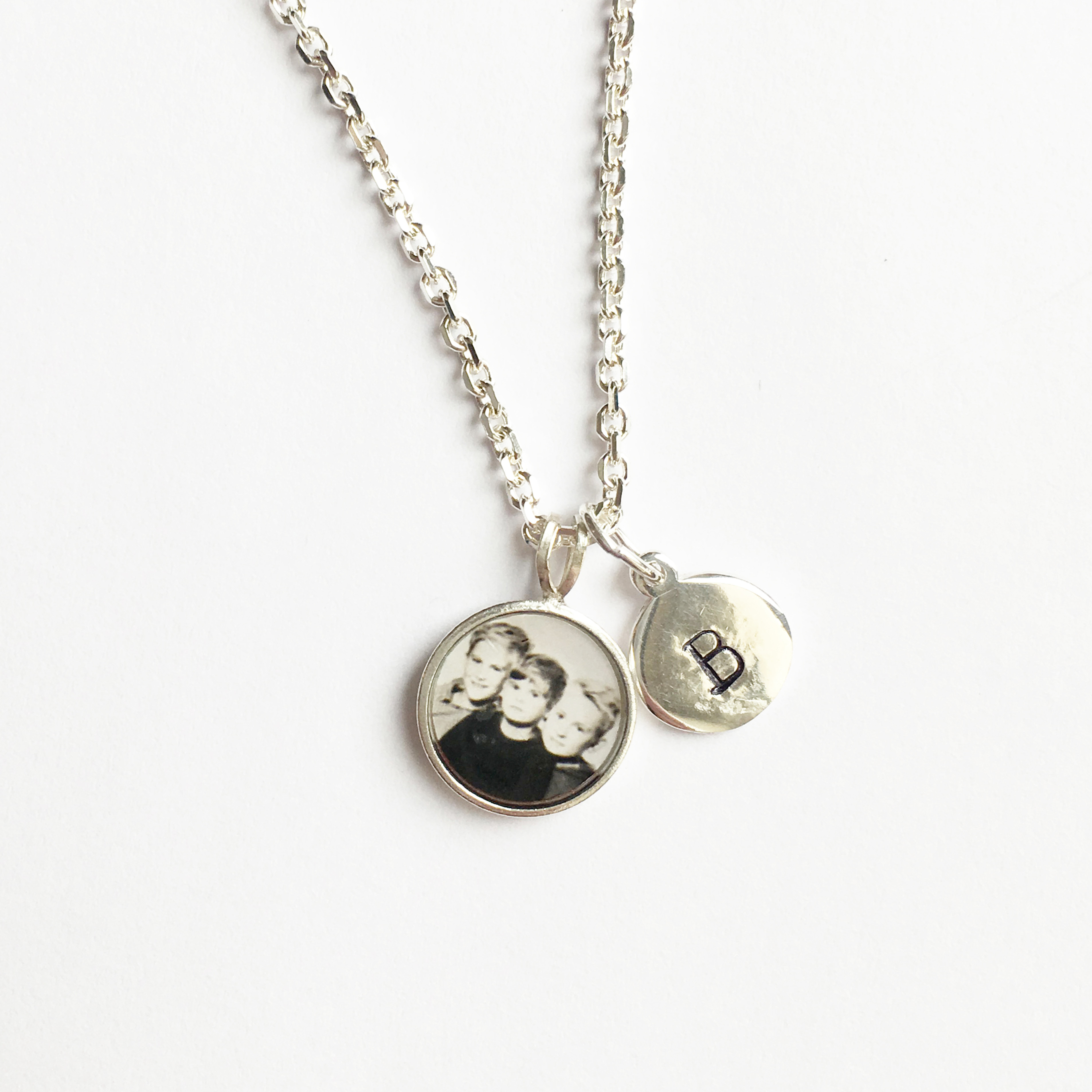 small round photo pendant on chain with stamped tag of letter B