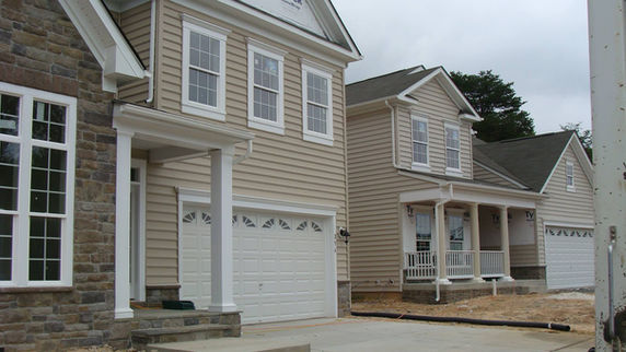 5 inch white gutters and downspouts installed on cream siding house in Glen Burnie Maryland