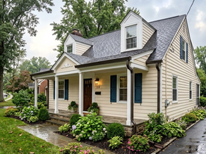 A charming Cape Cod-style similar to homes in Catonsville, MD, with cream siding, blue shutters, and new dark gutters, pictured after a rain on a lush suburban street.