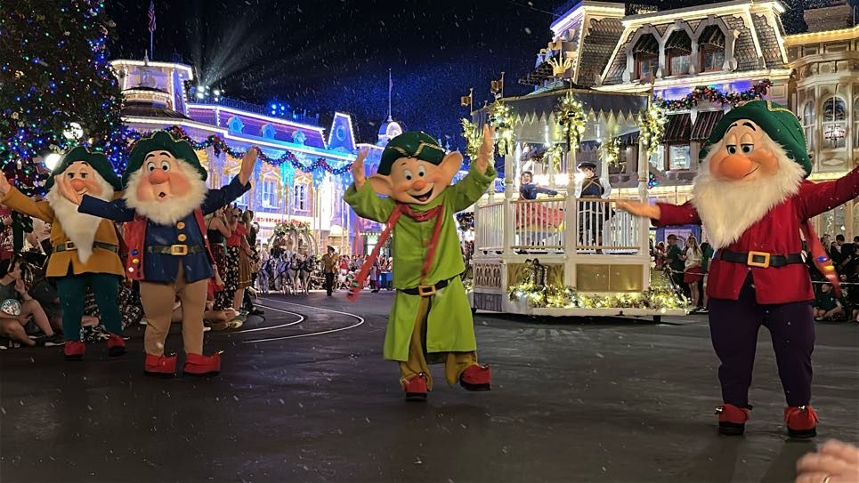 Seven Dwarfs in a Christmas parade on Main Street, U.S.A. at night at Magic Kingdom