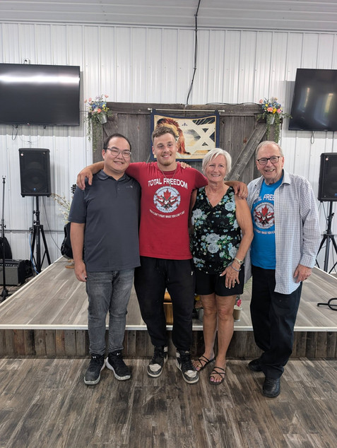 Four people posing together on a stage at a gallery event.