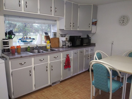 Gray kitchen cabinets and blue chairs in a dining area