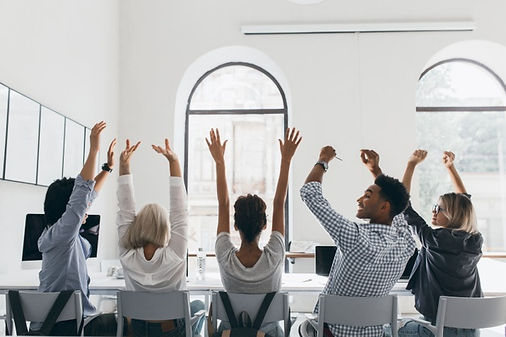 woman-formal-shirt-with-blonde-hair-waving-hands-sitting-coworkers-big-light-conference-ha
