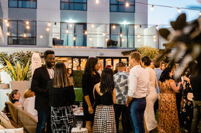 Professionals networking at an outdoor courtyard event at dusk