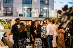 Professionals networking at an outdoor courtyard event at dusk