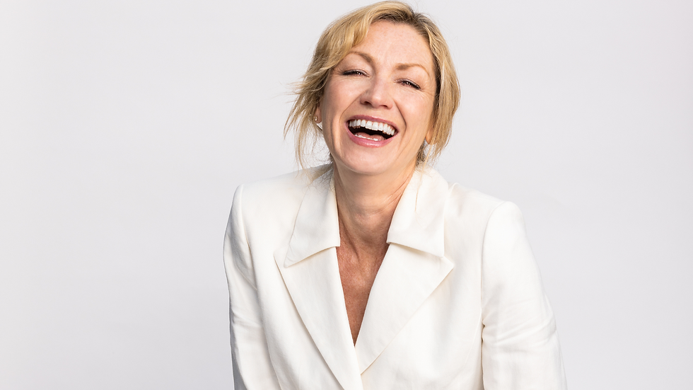 Midlife lady sat on a chair in a white suit