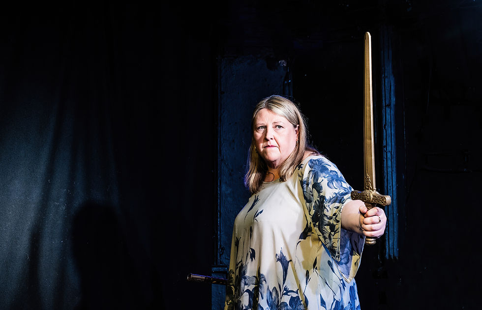 Joann Condon holding a prop sword on stage