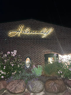 Schrift Helenenhof leuchtet im dunkeln auf dem Gebäude