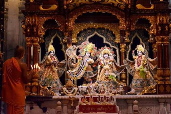 Deities of Radha and Krishna adorned with colorful clothing and ornaments inside ISKCON Juhu Temple