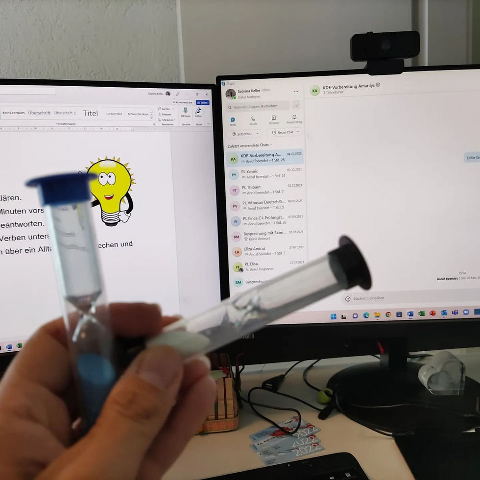 Sanduhren, im Hintergrund Laptop mit Skype