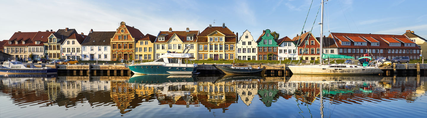 Historische Häuser und Segelboote am Glückstädter Binnenhafen