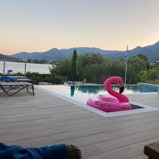 Sunset over the sea, the pool, and the pink flamingo