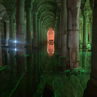 Roman columns in water bathed in green and red light