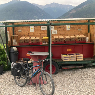 A bike in front of an apple juice stand 