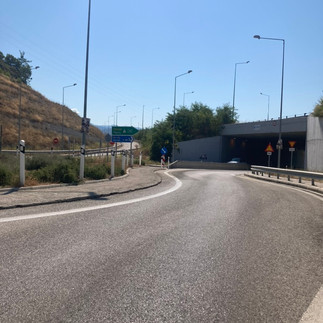 A tunnel with a sign for Patras in front of it