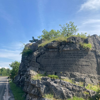 A stone hill with statues of wolves atop it