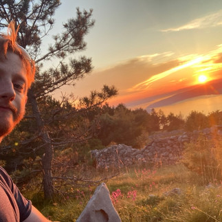 Me in front of the sunset over the distant sea