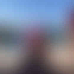 A pool with a pink flamingo float in front of the sea