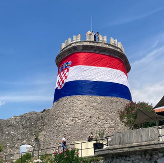 the croatian flag wrapped around a stone tower