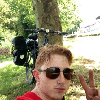 A man in sunglasses sat in the shade of a tree