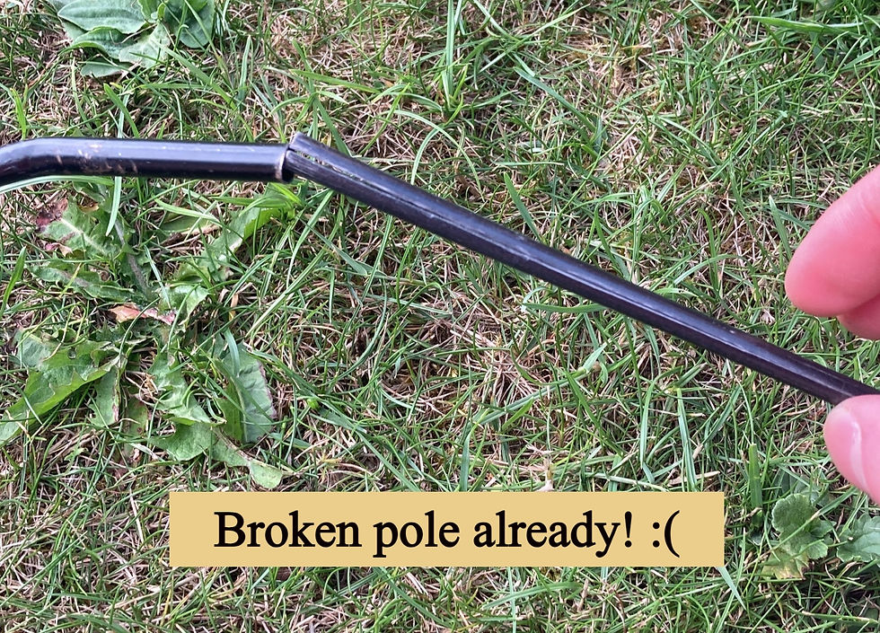 A broken tent pole in front of grass