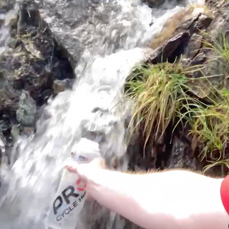 A bottle collecting water from a stream