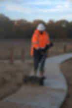 Man using power broom to clean sidewalk