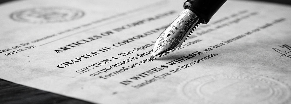 Flow tip pen pressed against a business filing legal document.