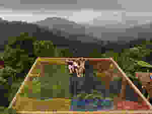 Three adults on hammocks over edge of mountain in Minca, Colombia