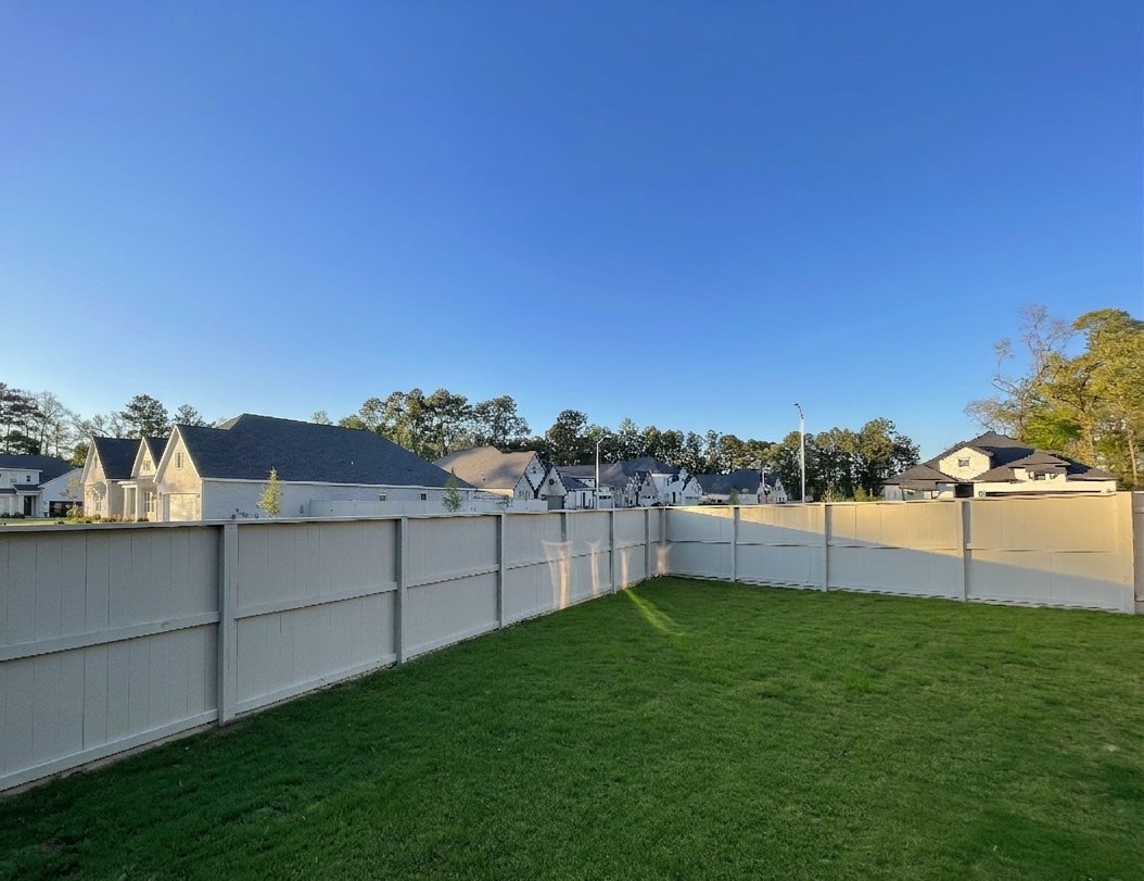 Before — open builder lot with vinyl fence and no privacy
