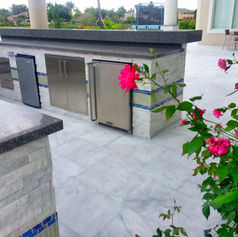 Outdoor kitchen with stainless steel appliances and pink flowers Kitchens & Pizza Ovens