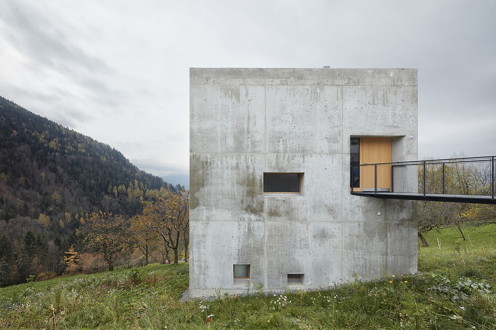 House Schmieder, a compact 8x8 meter cubic concrete residence in Fraxern, Austria, represents a distinctive response by Fischer Schmieder Architekten to its alpine setting. The house is situated on a gently sloping meadow, surrounded by cherry trees, and is accessed via a small steel bridge. The design process was centered on creating an appropriate and contemporary architectural statement that respects its rural, traditional surroundings.
The raw, monolithic design features thick, 50cm-wide insulating concrete walls, with all surfaces left untreated. This choice, combined with the use of raw steel and silver fir, creates a robust and elemental interior and exterior. The living spaces are distributed vertically across three floors, linked by an open staircase, which contributes to the building's open and spacious feel despite its compact footprint. Heating is integrated directly into the concrete core, supplemented by a central furnace for additional warmth. The project balances a minimalist, brutalist aesthetic with the surrounding landscape, providing a striking yet functional refuge.
Credits
Architecture: Fischer Schmieder Architekten
Photography: Adolf Bereuter