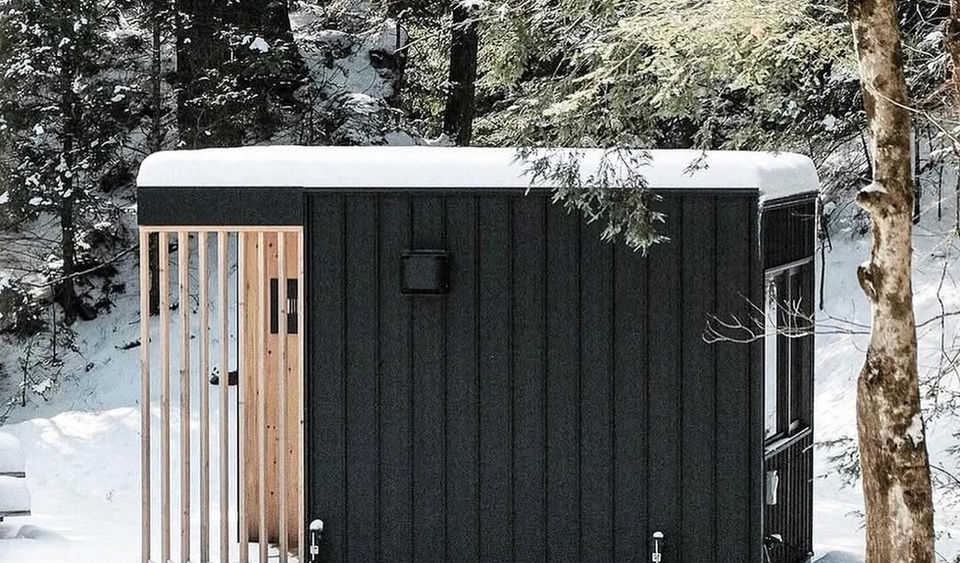 Cécile Lodge is a modular, off-grid tiny home built by Go-Box, located in a wooded area in Lac-Mégantic, Quebec. Designed as a prototype for a new resort project, the lodge is intended for adventure lovers, offering ski-in/ski-out and bike-in/bike-out access. The project emphasizes a strong connection to nature and a flexible, space-efficient living experience, inspired by the "van life" movement. 

The Go-Box design philosophy revolves around offering portable, prefab structures that can be combined and customized. For Cécile Lodge, the clients needed a small space with large floor-to-ceiling windows to invite the outdoors in. The result is a highly functional interior that incorporates movable, built-in furniture, reminiscent of a game of Tetris. A key feature is the convertible living area, which uses a pull-out bed to transform the main space into a large bedroom at night, suitable for a couple with two children. 

The interior boasts a simple aesthetic with finishes made from either Russian ply or pine. A small kitchenette is integrated into the layout, featuring a gas stove, kitchen accessories, and a mini-fridge. A full bathroom with a toilet and shower is also included. Outside, the lodge is finished with a low-maintenance steel exterior and a cedar or pine terrace, while inside, comfort is ensured with insulation and the option for a heat pump and heated floors. 

Located in the forest with mountain views, Cécile Lodge is off-grid but is equipped with a well and septic system. It serves as a retreat for those who wish to disconnect from daily life, refuel their energy, and immerse themselves in the surrounding natural environment.
 
Credits
Designer and Manufacturer: Go-Box (Emelie Holmberg)
Location: Lac-Mégantic, Quebec