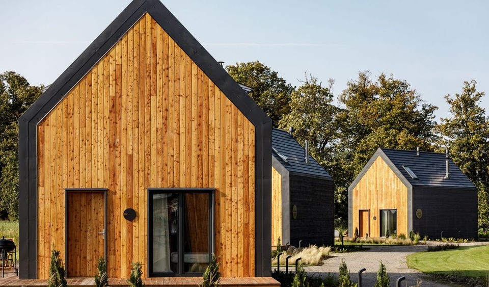 Przylądek Marzeń is a coastal retreat project designed by LOOKA studio, combining a passion for travel, nature, luxury, and adventure into five uniquely themed holiday houses. The resort is located in Wieniotowo, Poland, near the Baltic Sea coast, and was built based on the owners' travel experiences and desire to create a perfect, relaxing getaway. The design of the holiday homes aims to combine comfortable accommodation with the surrounding wild nature, with each of the five houses named to evoke a specific feeling: Pasja (Passion), Wolność (Freedom), Spokój (Peace), Oddech (Breath), and Bliskość (Closeness). The homes, each 63 square meters, are equipped to a high hotel standard, and four of them feature private saunas and hot tubs on the terraces.
The site's layout was meticulously planned by LOOKA studio, with the houses arranged radially to give each guest a sense of private space, and large terraces offer panoramic views of the surrounding fields and countryside. The project was developed in stages, with the expansion that revealed the Bliskość and Oddech houses being highlighted in mid-2022. In addition to the adult-focused amenities, the resort is designed to be family-friendly, featuring a "Kids Club" with three separate playrooms for different age groups, a large playground, and a bonfire area. The homes are also well-equipped for families, with safety gates on the stairs, baby baths, and high chairs. For active guests, the retreat is situated just 300 meters from the Velo Baltica cycling route and 400 meters from the beach. Guests can also order breakfast baskets filled with local products, which are delivered directly to their homes.
Credits
Designer: LOOKA studio
Host: Marzena, the property owner