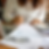 Close up of woman holding a pencil while doing her tax returns which are on the table in front of her