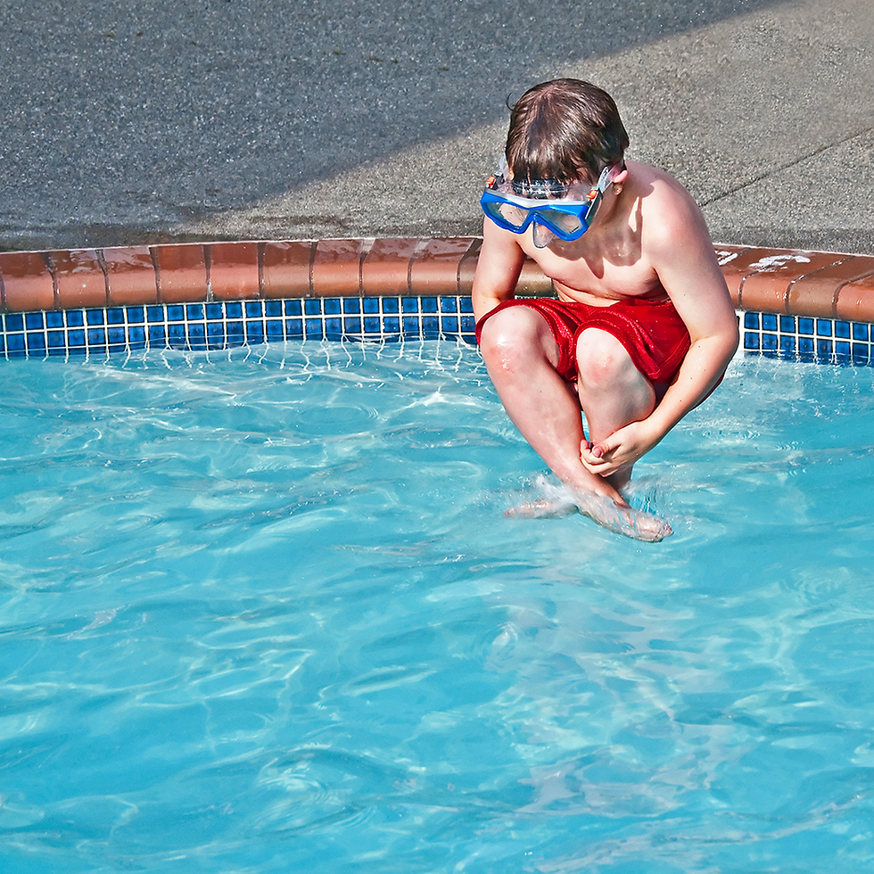 Young boy in red swim suit and blue goggles doing a cannonball into pool - what could go wrong?
