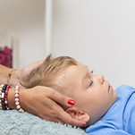 Woman healer performing access or consciousness bars to young boy, pseudoscientific method