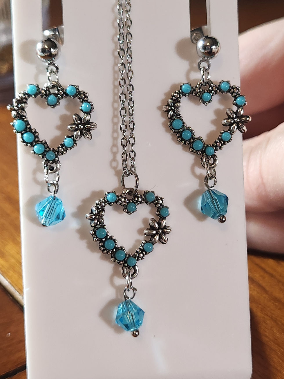 Turquoise heart-shaped necklace and matching earrings with dangling blue beads.