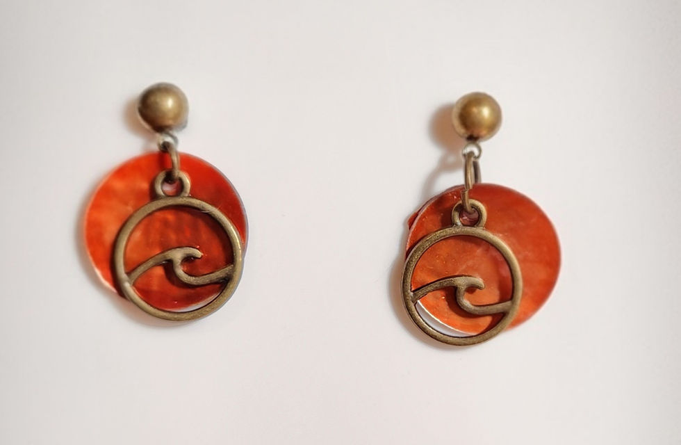 Pair of round orange dangle earrings with stylish wave design.
