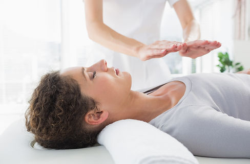Attractive young woman having reiki treatment in health spa.jpg